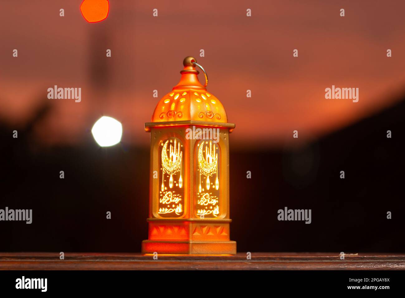 Decorative Arabic lanterns with burning candles at night. Glittering golden bokeh lights. Festive greeting card, invitation. Muslim holy month Ramadan Stock Photo