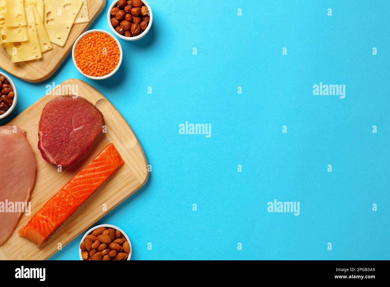 Different fresh products on light blue background, flat lay and space for text. Sources of