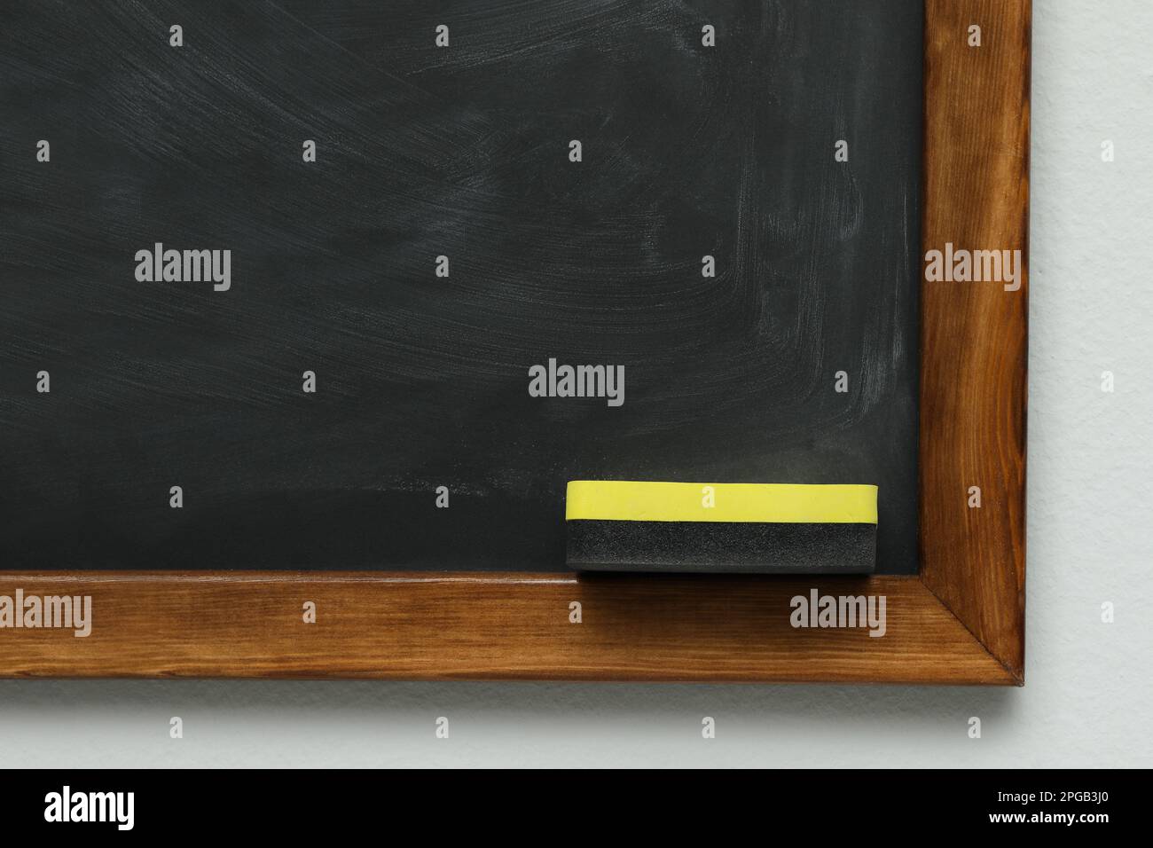 Dirty black chalkboard with duster hanging on grey wall Stock Photo Alamy