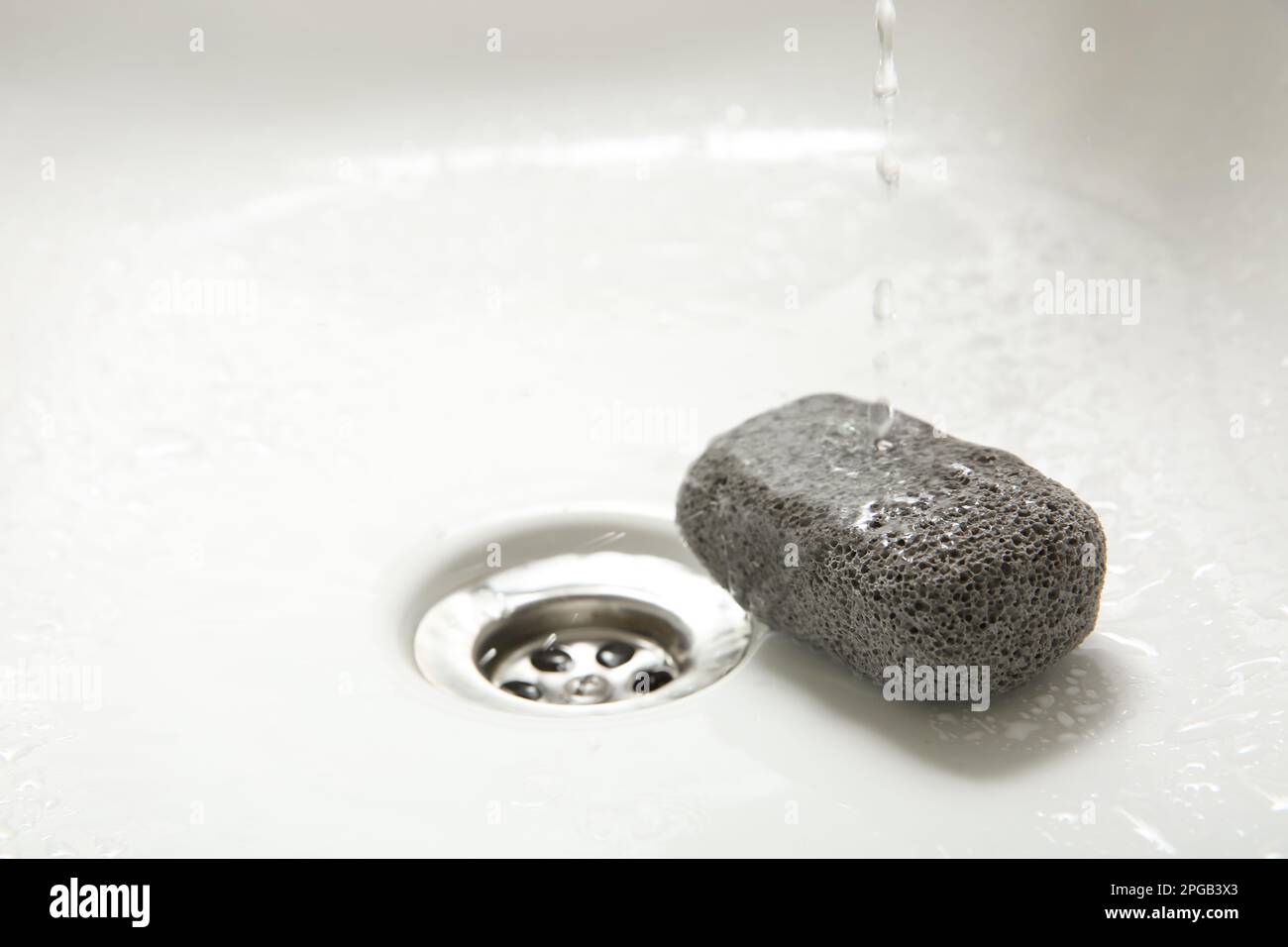 Pouring water onto pumice stone in sink, space for text Stock Photo Alamy