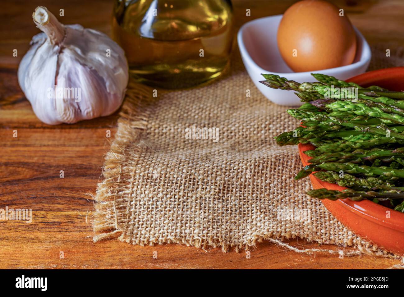 Closeup of wild asparagus in an earthenware casserole with olive oil