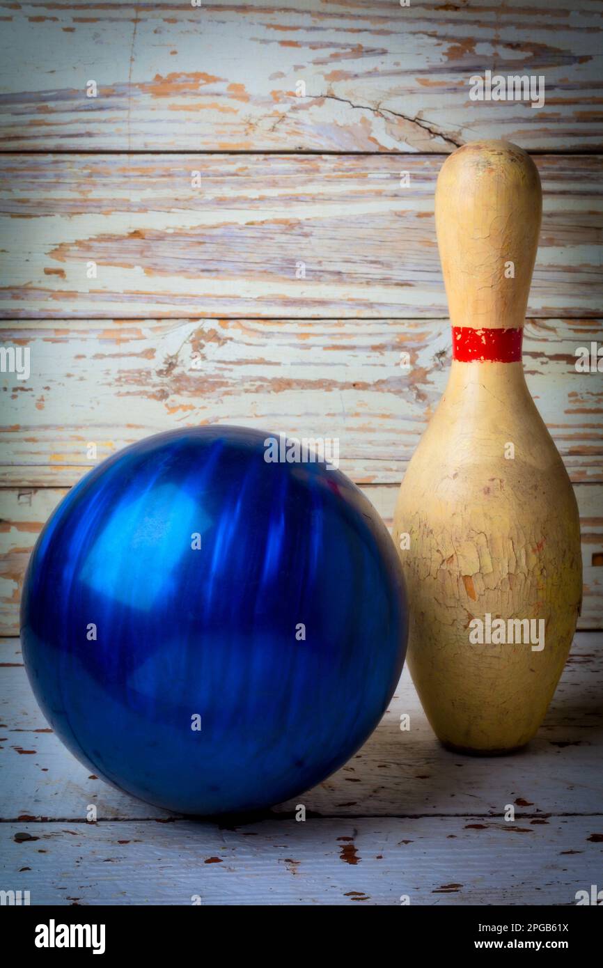 Old blue bowling ball and weathered Worn bowling pin Still life Stock Photo