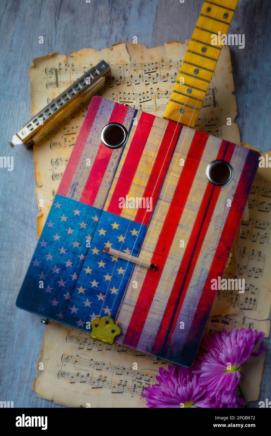 Cigar Box guitar And Harmonica With Sheet Music Still life Stock Photo
