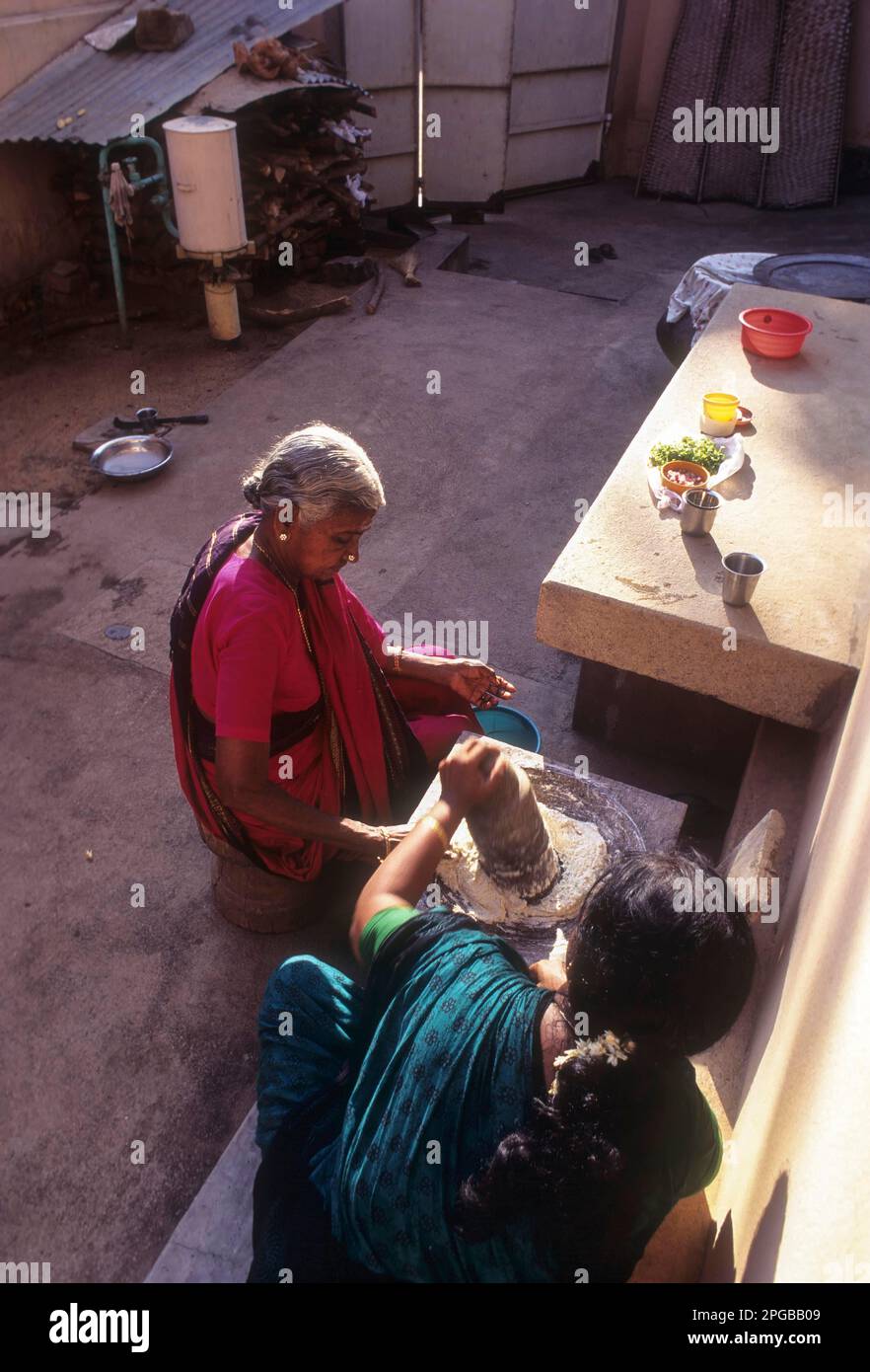 Women making batter in Aatu Kallu or grinding stone in Chettinad, Tamil ...