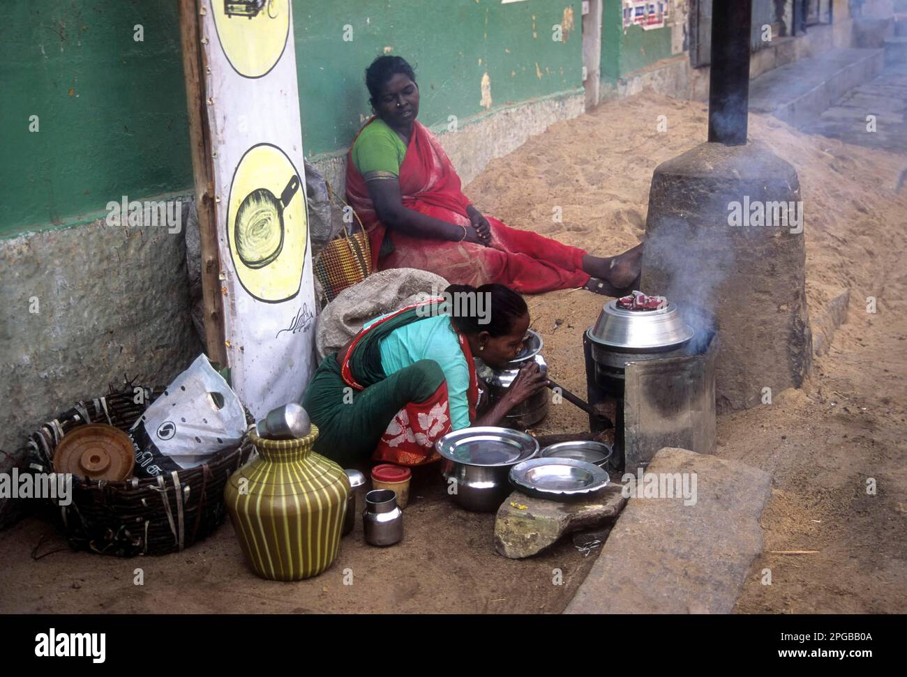 An old woman preparing idlis; idlys on the side of the road at Madurai, Tamil Nadu, India Stock Photo