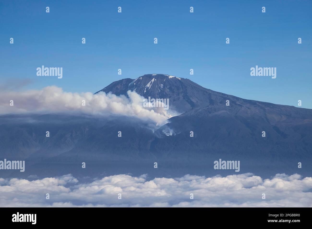 Aerial view, mountain peak of Kilimanjaro volcano with forest fire and smoke on the mountain flank, Tanzania, East Africa Stock Photo