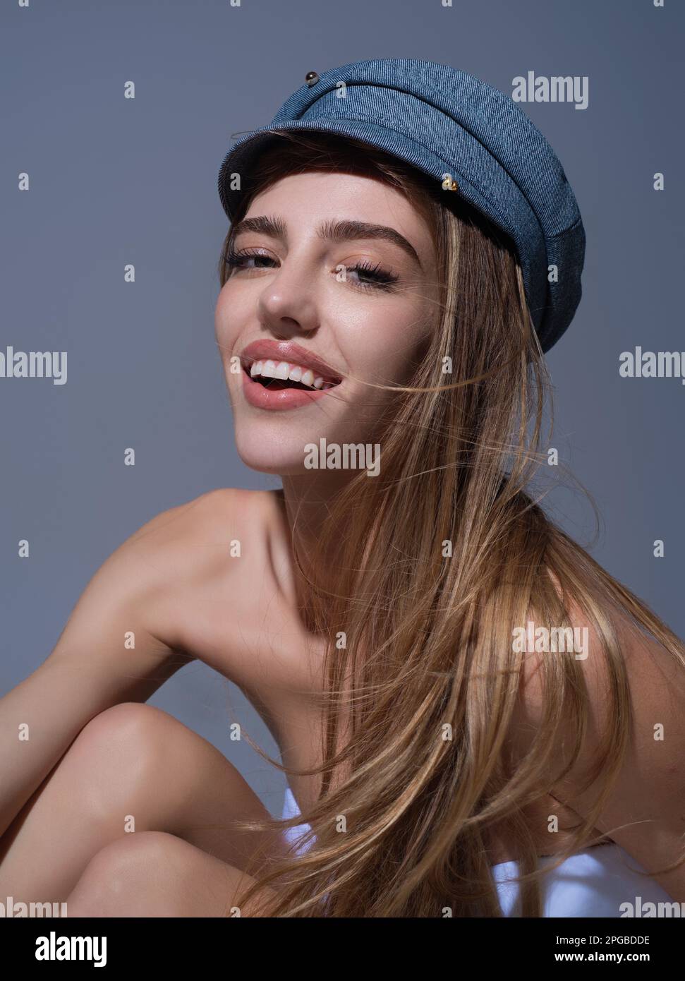 Beautiful sensual young woman in fashion cap hat, close up studio portrait. Beautiful model, sexy girl face. Fashion and beauty. Stock Photo