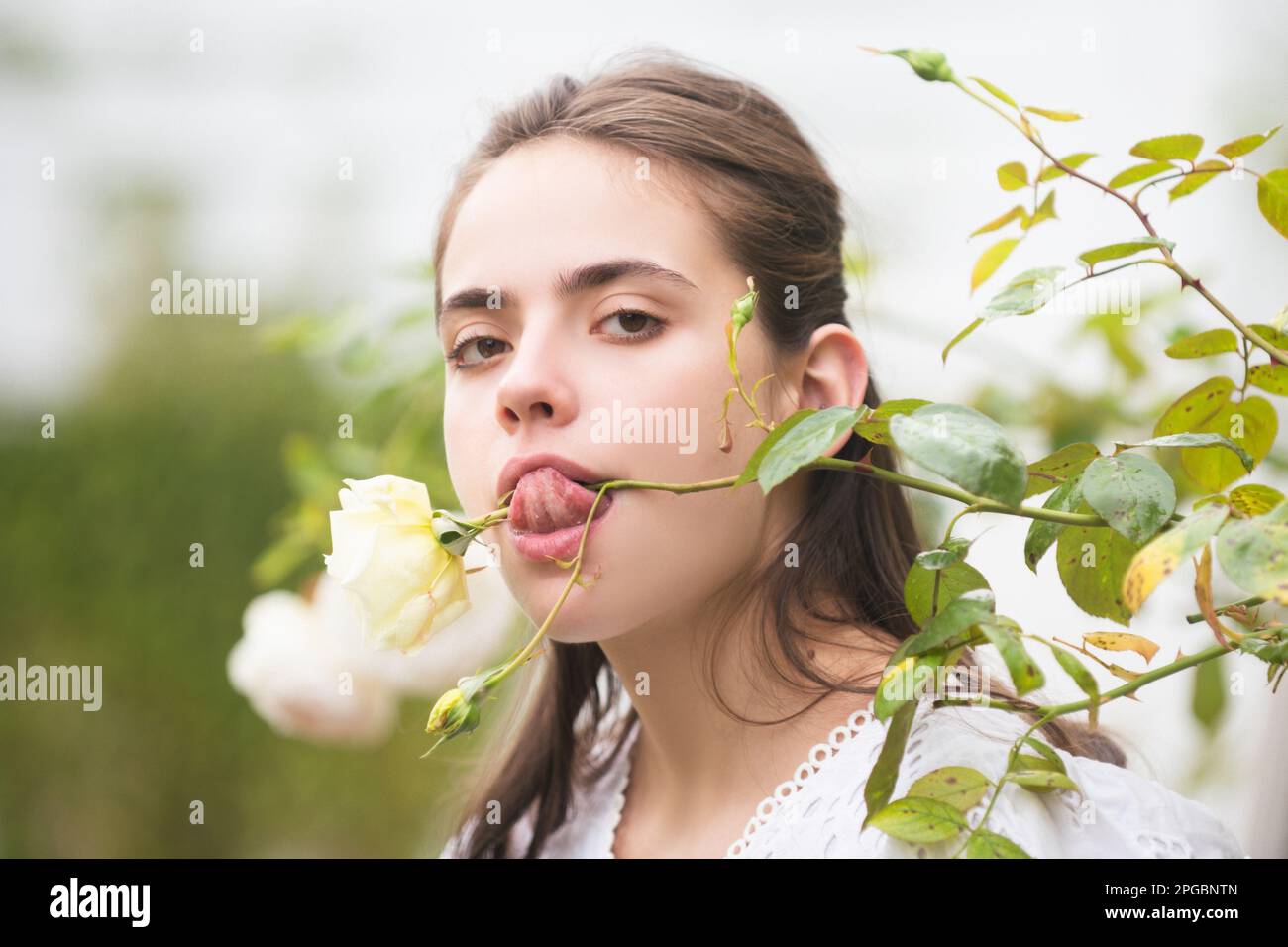 Spring girl. Young woman enjoying blooming spring garden. The concept of youth, love, fashion and lifestyle. Beautiful young girl in the park and a Stock Photo