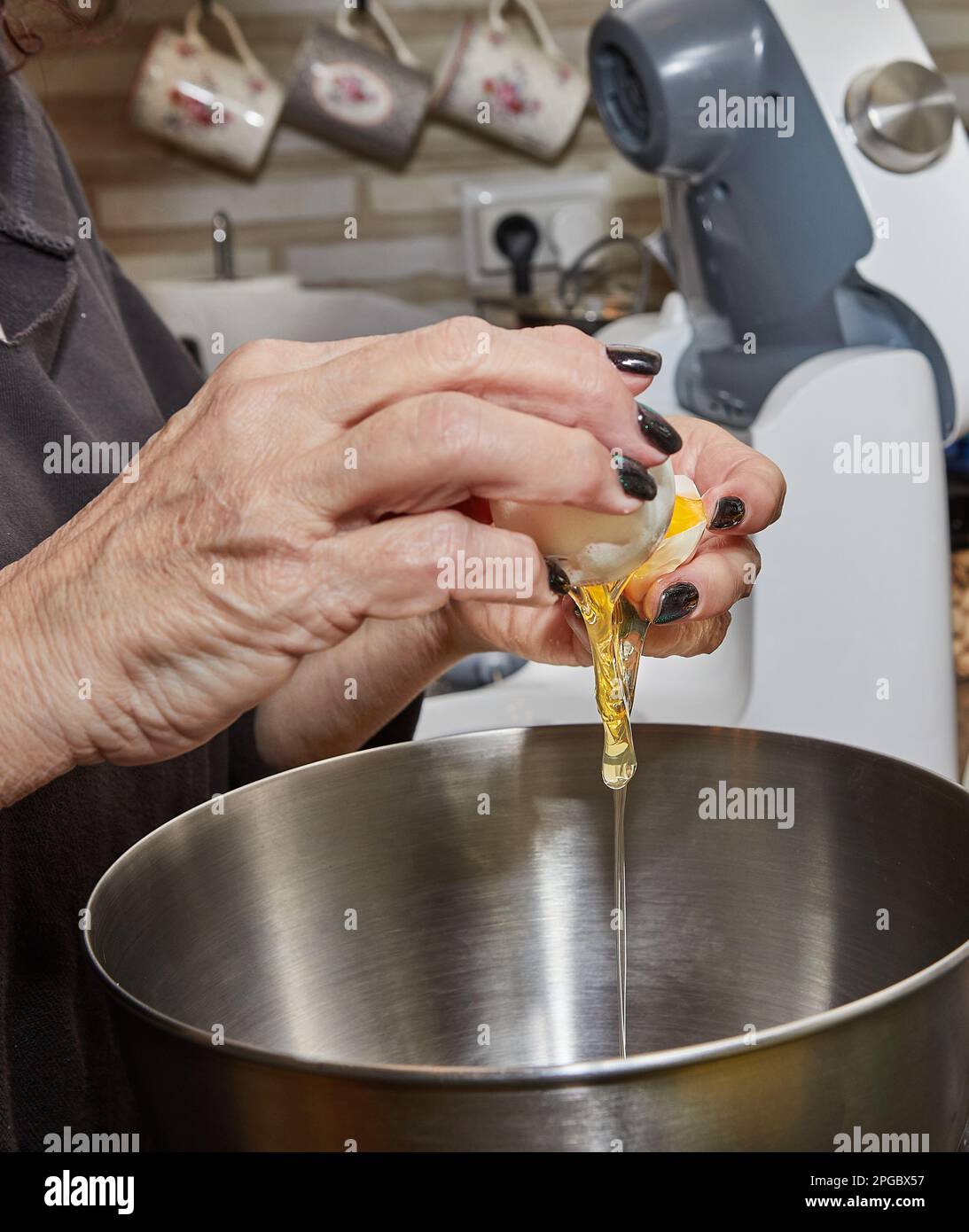 Chef cracks an egg into dish that is being prepared in bowl Stock Photo