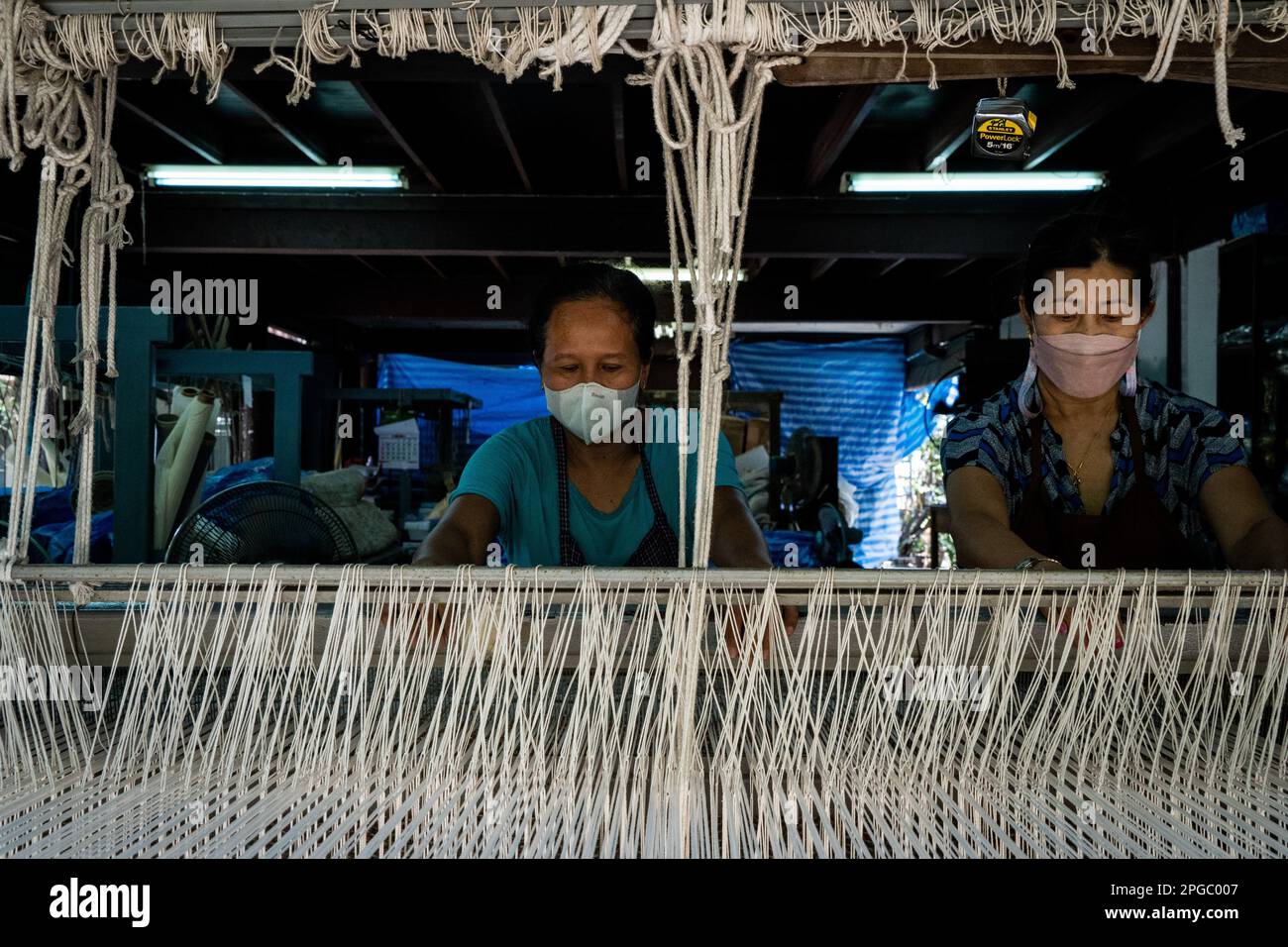 Bangkok, Thailand. 22nd Mar, 2023. Workers use a loom to make a rug out of recycled fabric and