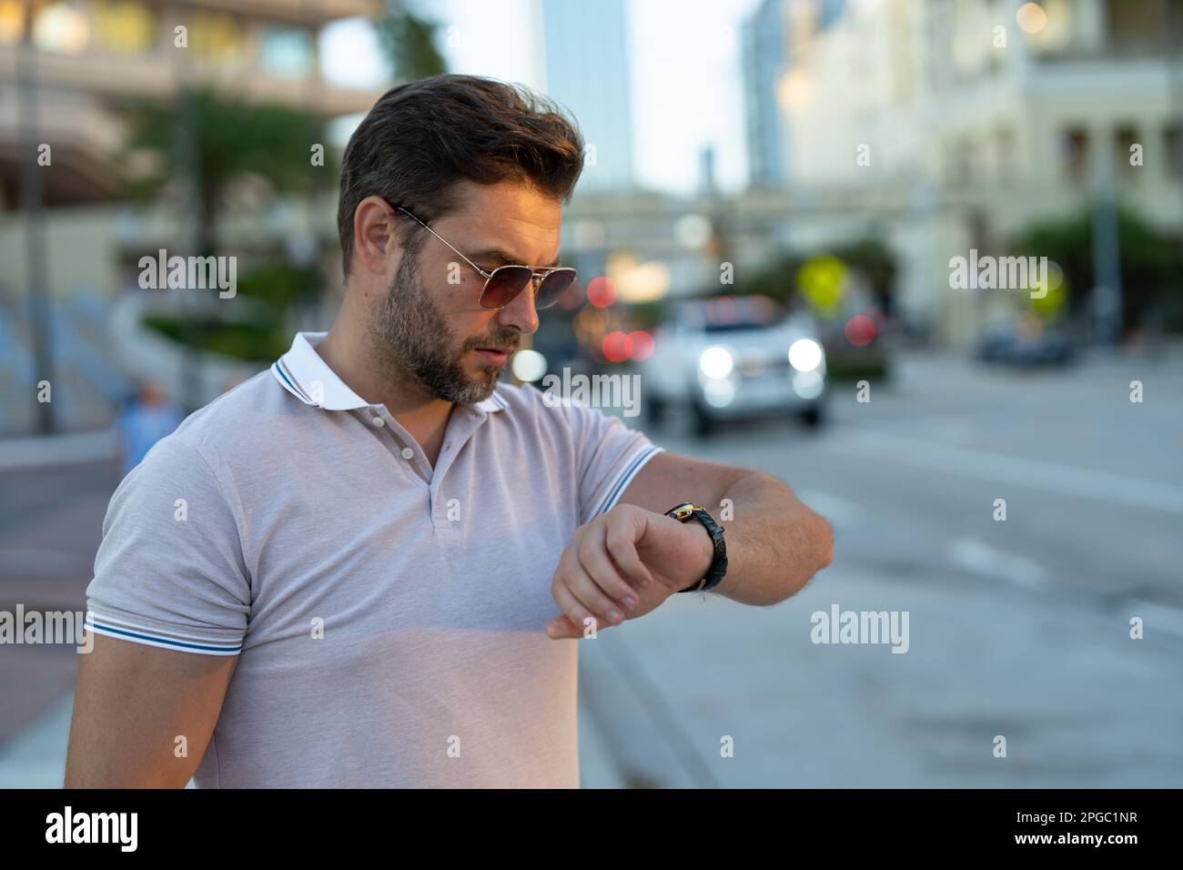 Stylish man wearing sunglasses and shirt. Handsome man outdoors portrait. Portrait of stylish male model outdoor. Fashion male posing near skyscraper Stock Photo