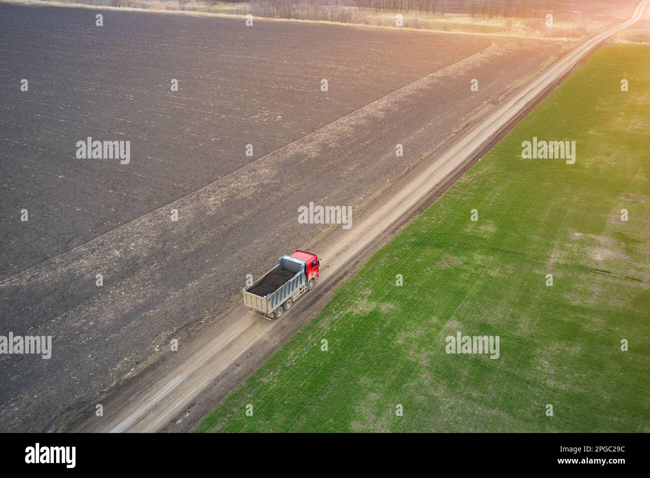 view from a drone of a dump truck moving along a field road Stock Photo