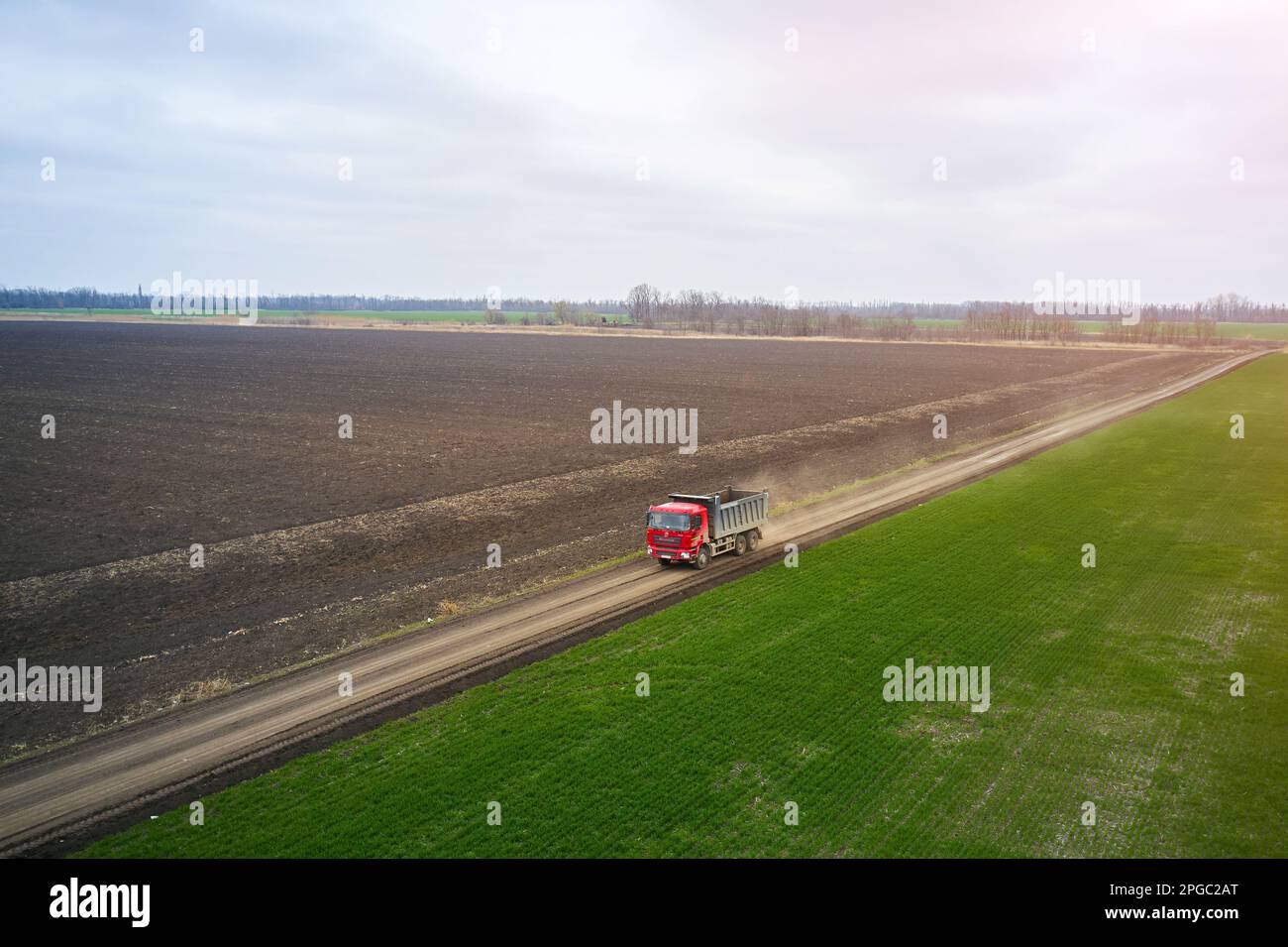 view from a drone of a dump truck moving along a field road Stock Photo
