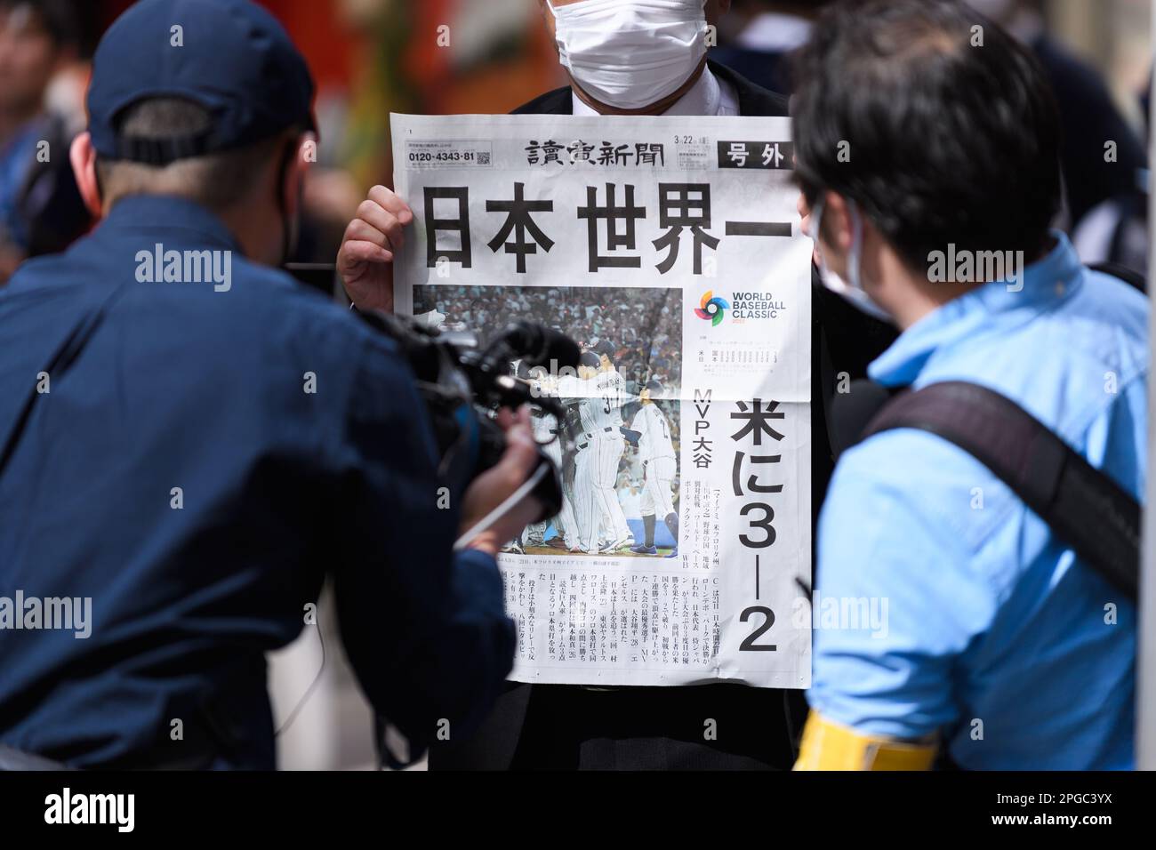 A baseball fan gets interviewed while holding a special edition version of the Yomiuri Newspaper celebrating Team Japan's victory in the 2023 World Baseball Classic final on March 22, 2023, in the Shibuya district of Tokyo, Japan. Japan defeated team USA 3-2 in the tournament final held in Miami to record their third championship title. Credit: Keiichi Miyashita/AFLO/Alamy Live News Stock Photo