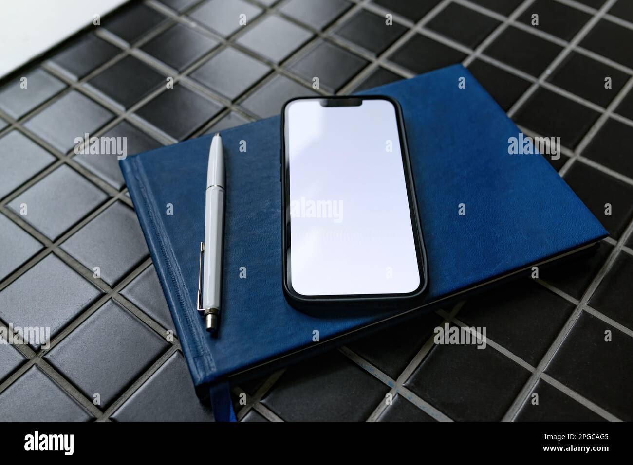 Smartphone mockup with guestbook and pencil in apartment room Stock Photo