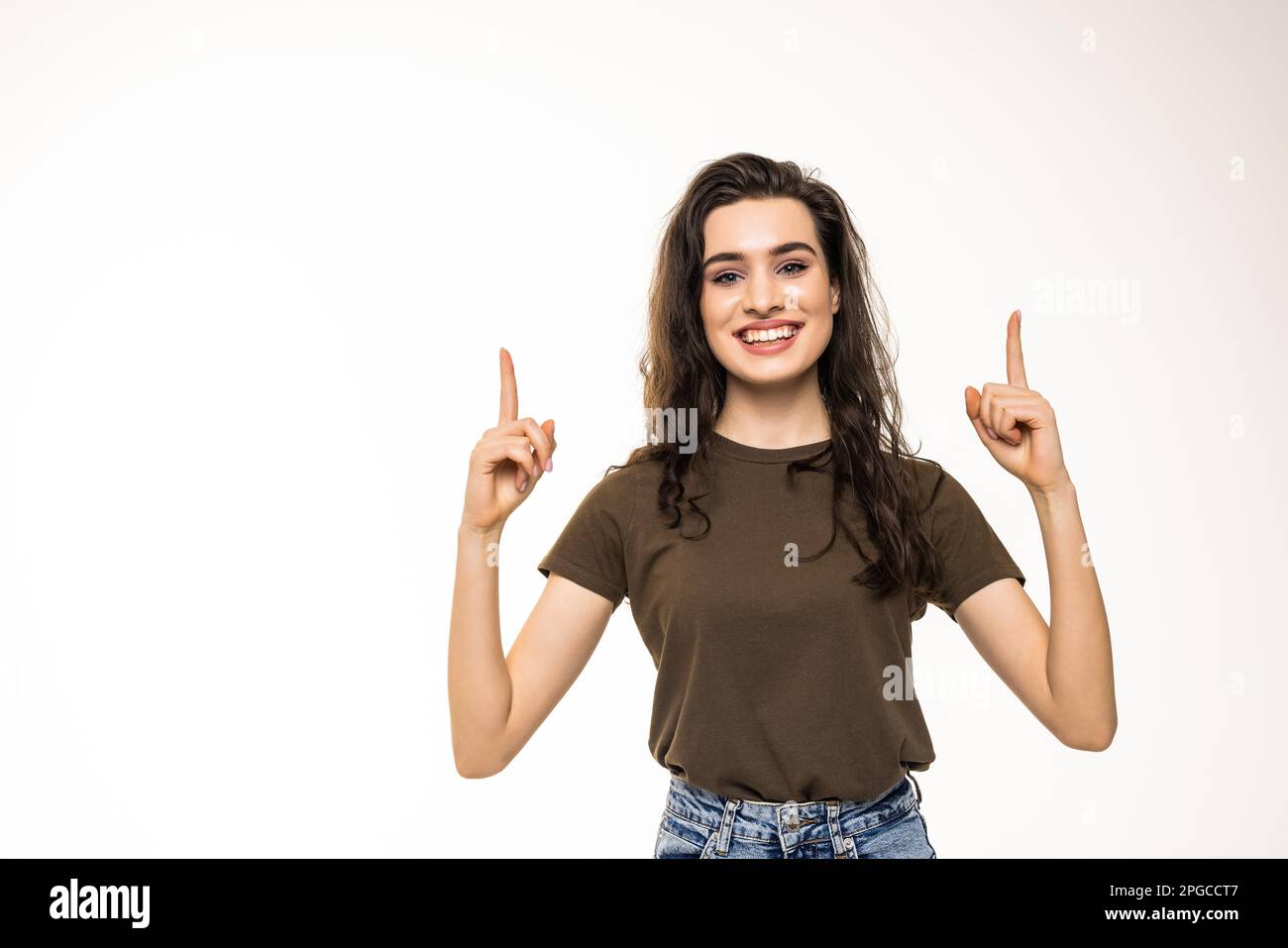 Thoughtful smiling woman with fair hair, raising finger and pointing up, having good point or idea, showing advertisement, standing against white back Stock Photo