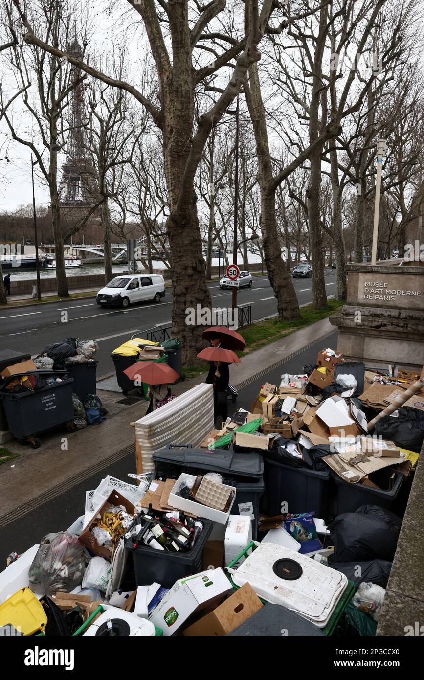 People walk past overflowing garbage bins near the Modern Art Museum and the Eiffel Tower as