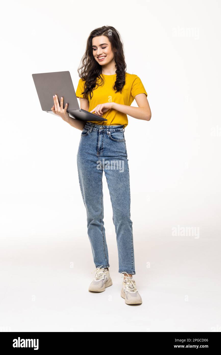 Beautiful young woman with laptop isolated on white background. Full body Stock Photo
