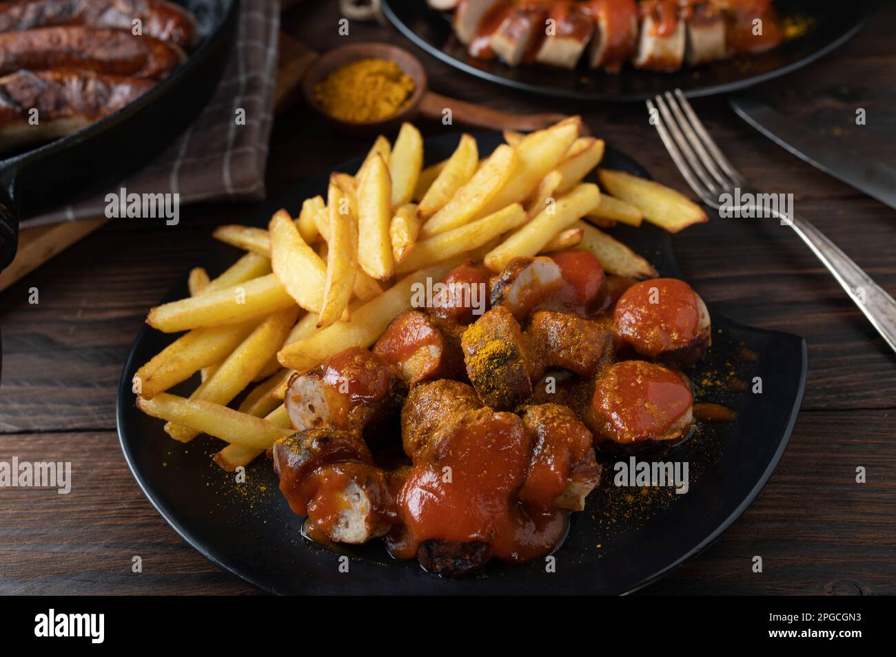 Curry Sausage or currywurst with french fries. Traditional german fast food meal. Homemade cooked Stock Photo