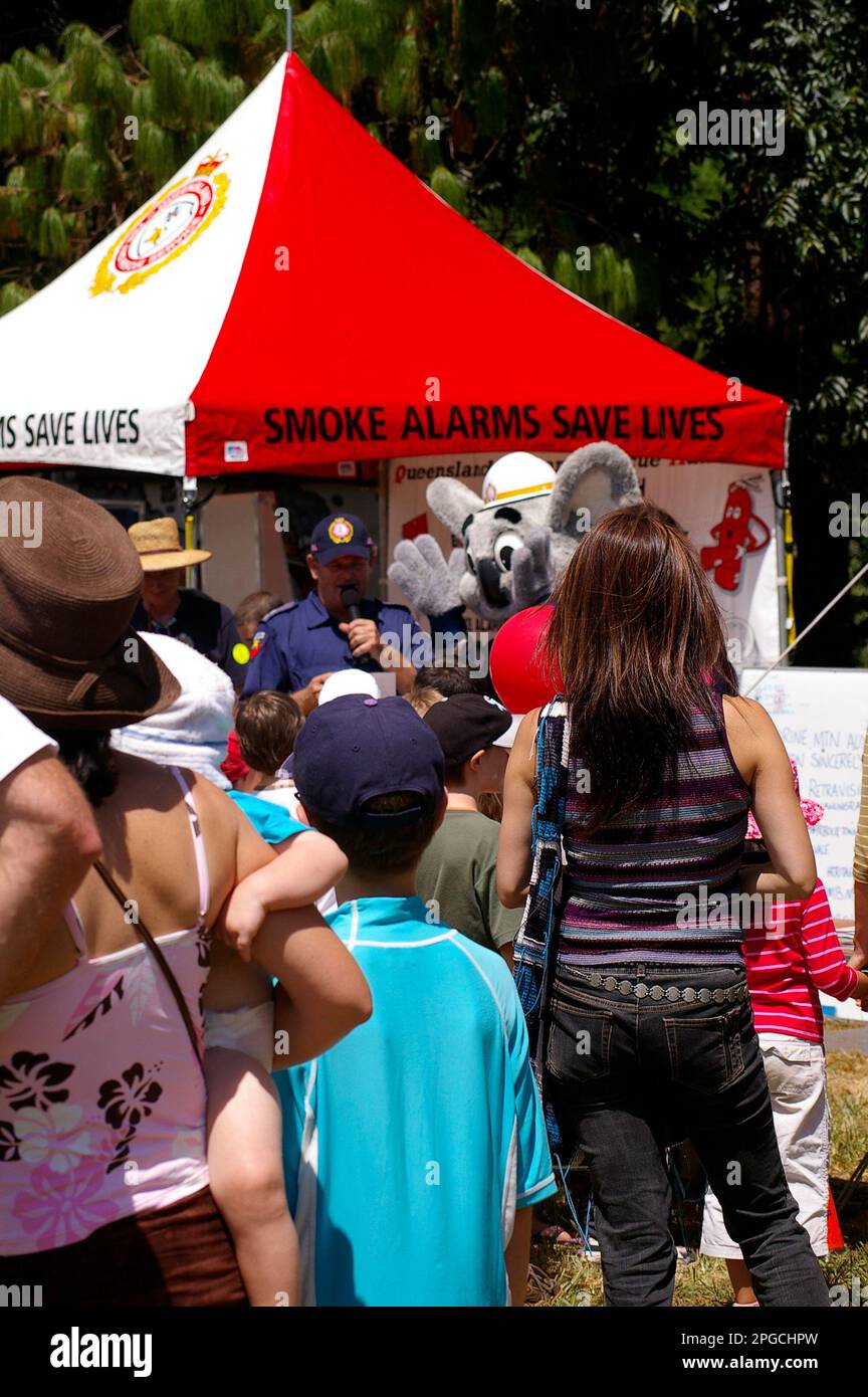 Visitors to Tamborine Mountain Show listening to talk by Queensland Fire and Emergency about smoke alarms. Fireman and mascot koala. Blazer. Australia Stock Photo