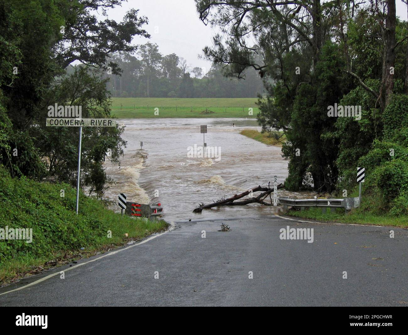 Old Birds Road disappearing under floodwaters of Coomera River, Queensland, Australia, in 2005. Road later diverted to avoid more flooding. Stock Photo