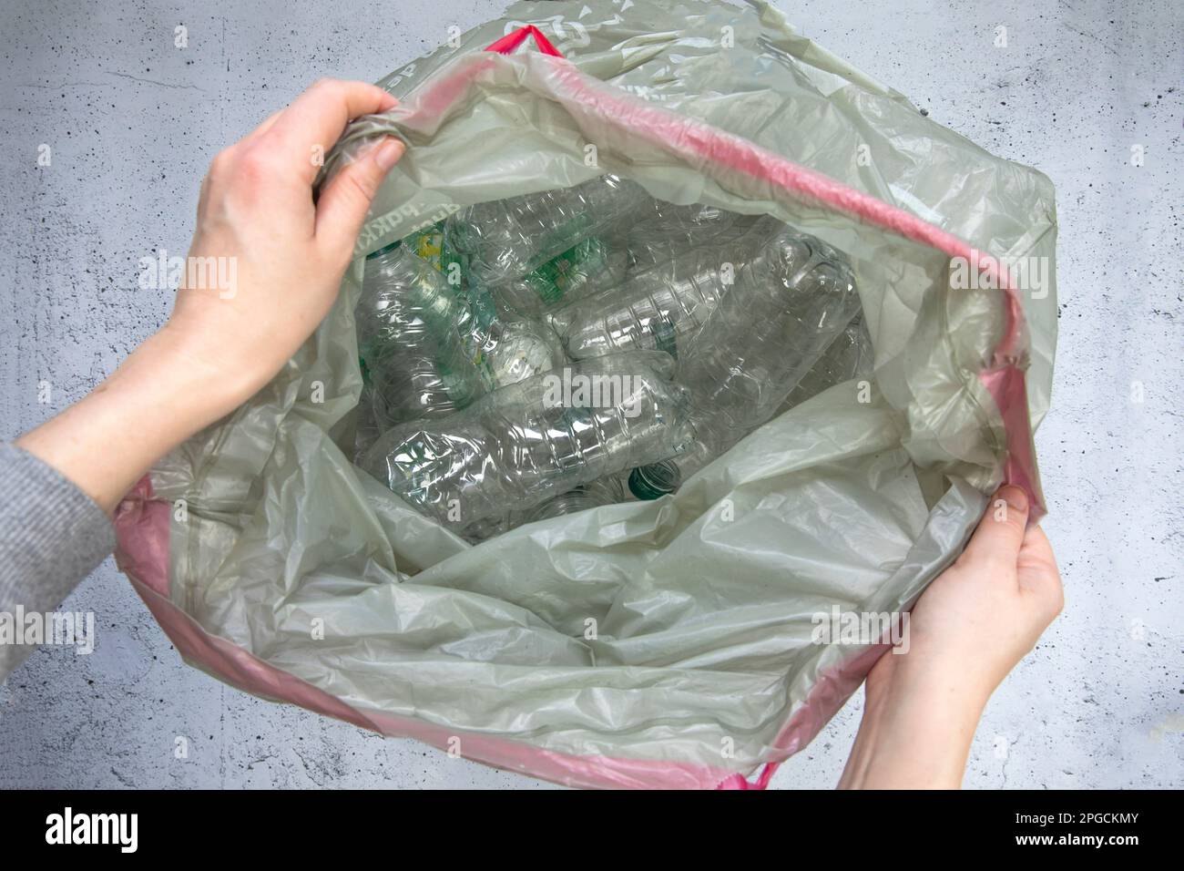 Hand getting plastic bottles to dispose in garbage bag ready to recycle