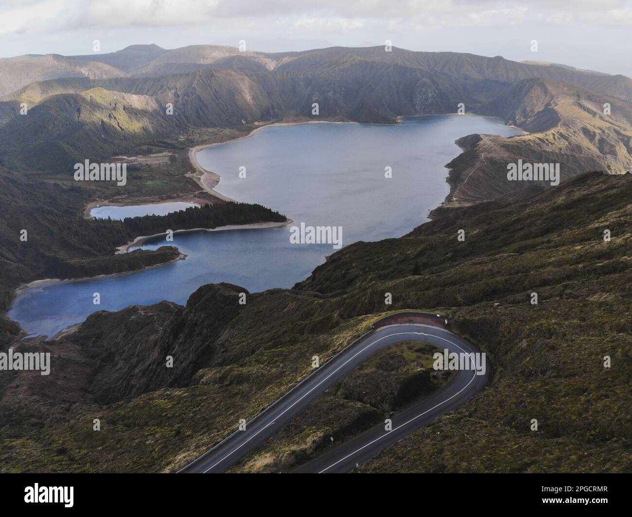 Aerial view of curved asphalt road among green hills in undulating ...