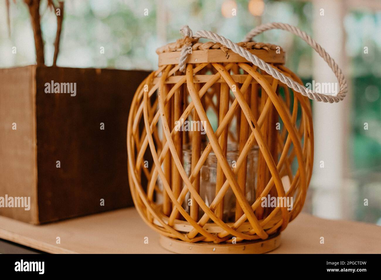 A decorative braided wicker basket with a rope handle, interior