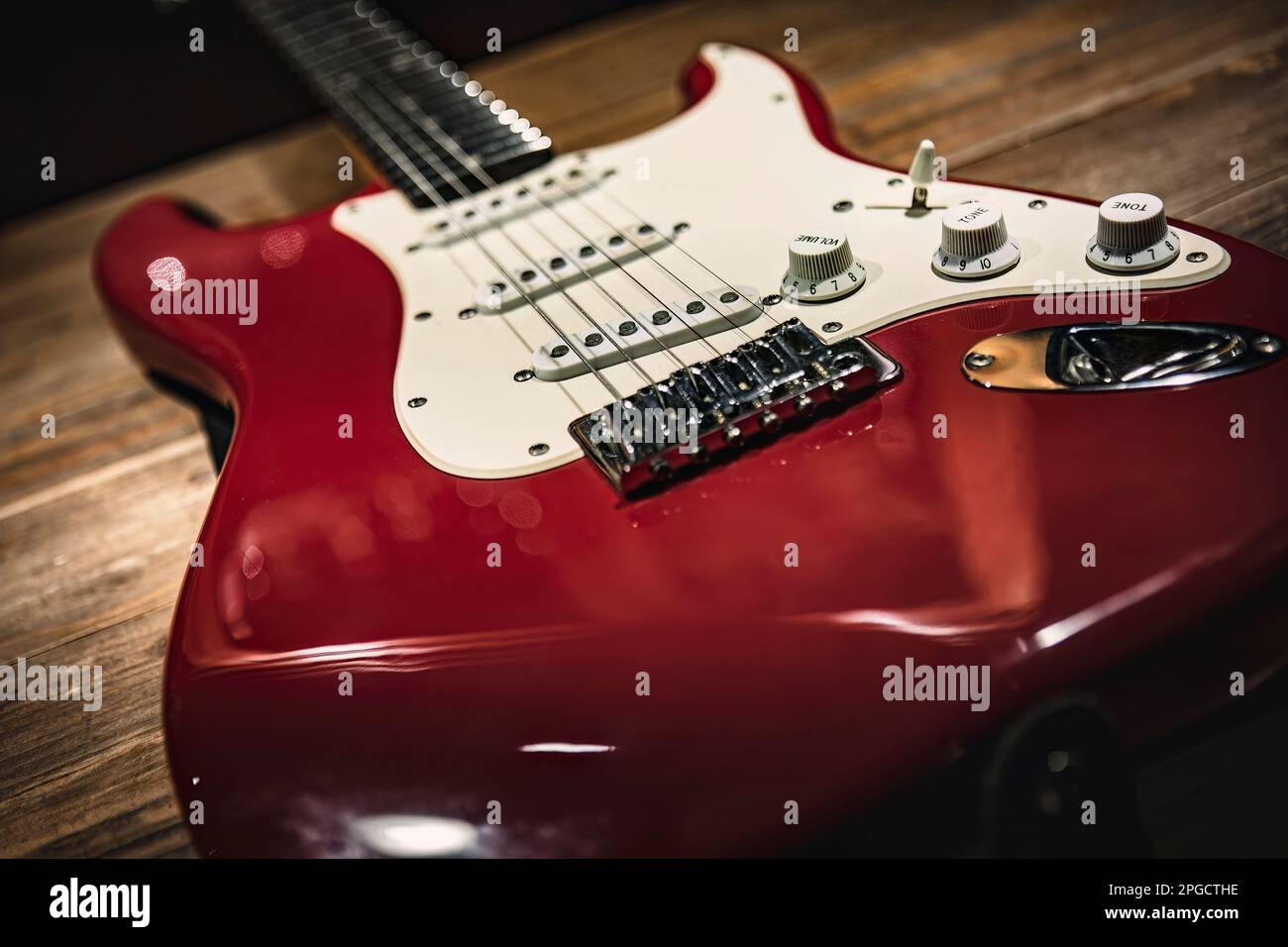 A detailed close-up shot of a red and white electric guitar, perfect