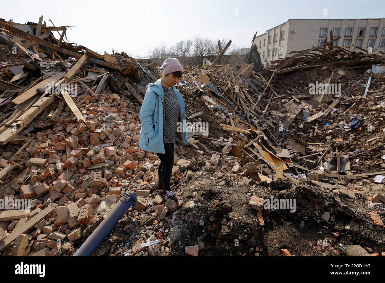 A woman stands next to a shell crater in the ruins of the water supply station building destroyed by recent shelling in the course of Russia-Ukraine conflict in Donetsk, Russian-controlled Ukraine, March 22, 2023. REUTERS/Alexander Ermochenko Stock Photo