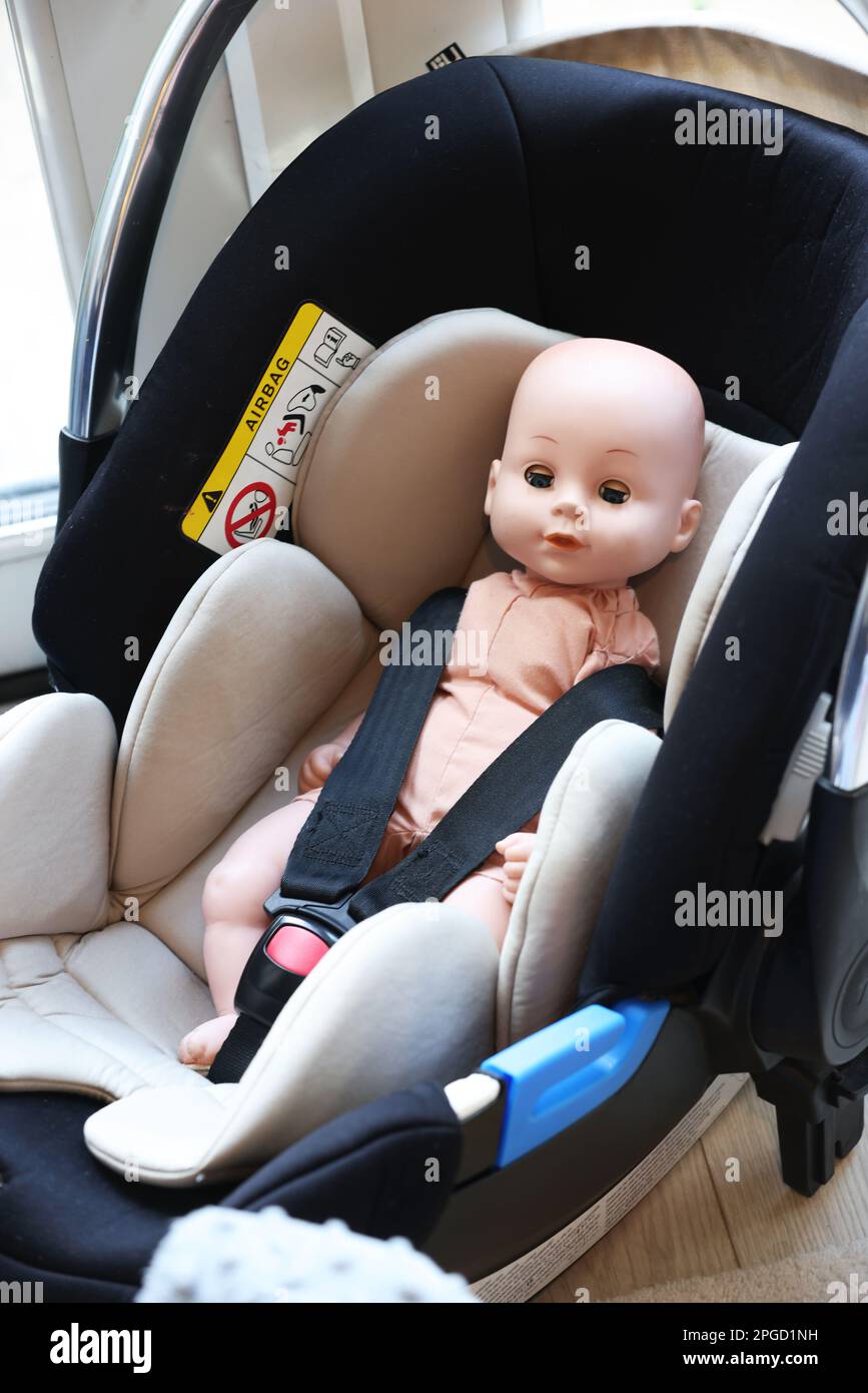 Toy baby pictured in a babies carseat in a home in Chichester, West Sussex, UK. Stock Photo