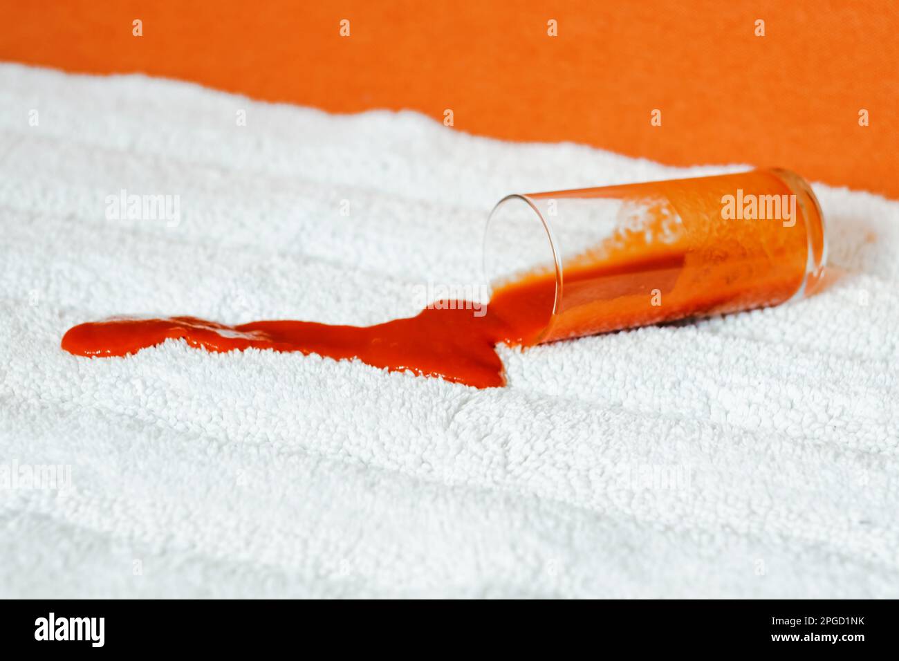 Tomato stain on a white carpet indoors. Spilling juice a glass on the