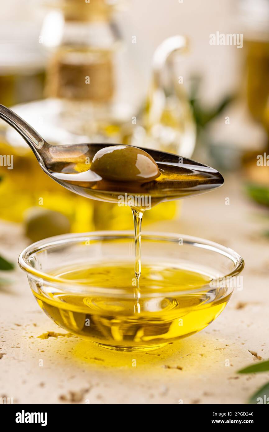 Green olive in spoon with extra virgin olive oil Stock Photo - Alamy