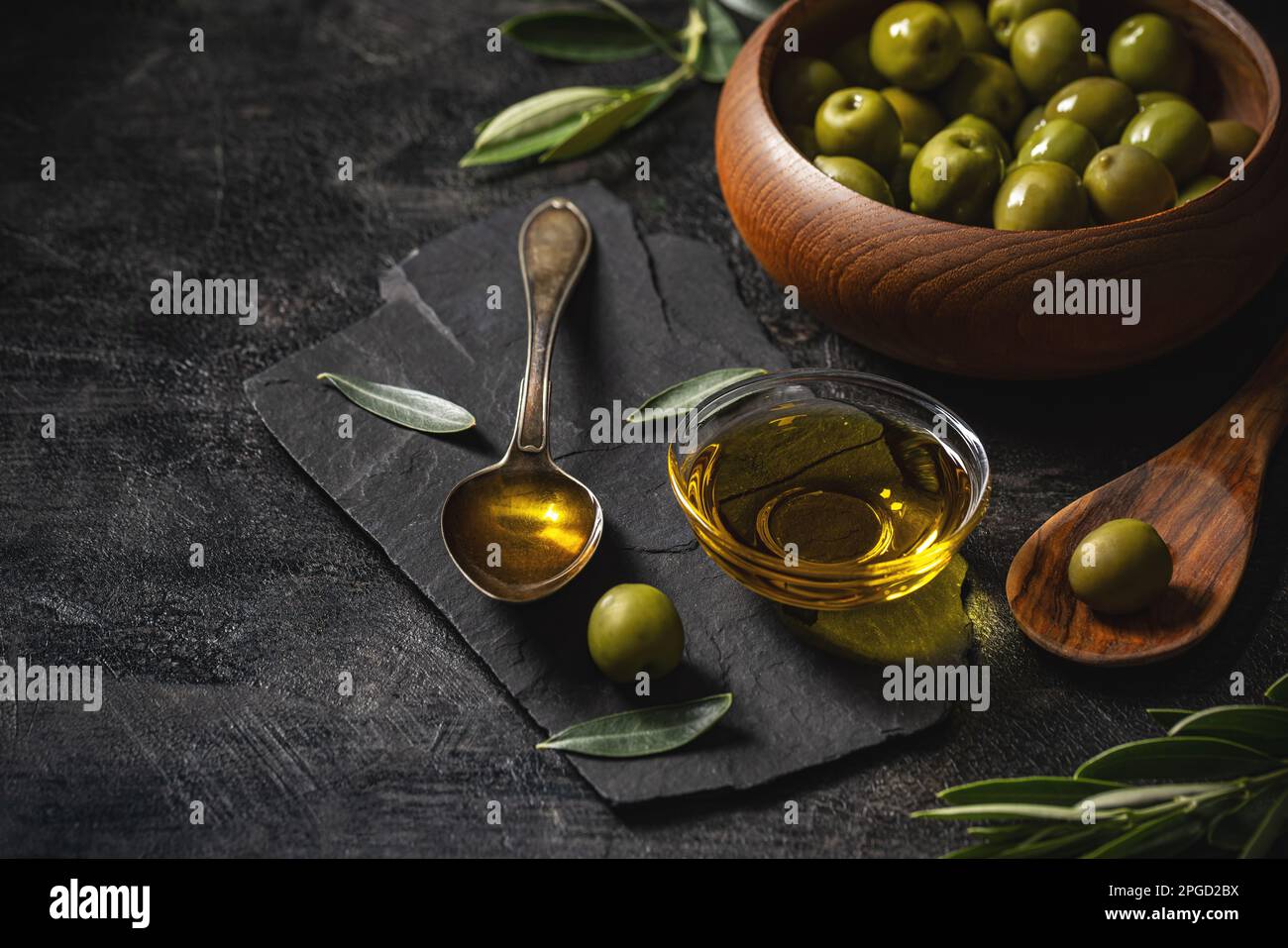 Mediterranean food concept with olives and extra virgin olive oil on black slate background Stock Photo