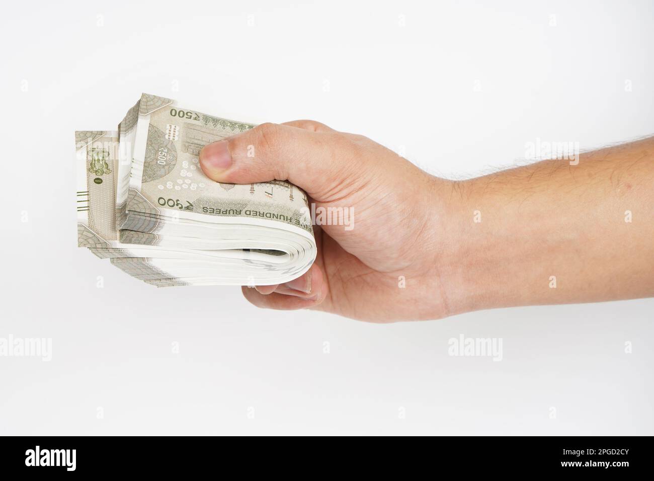 Hand holding pile of cash on white background, indian currency note