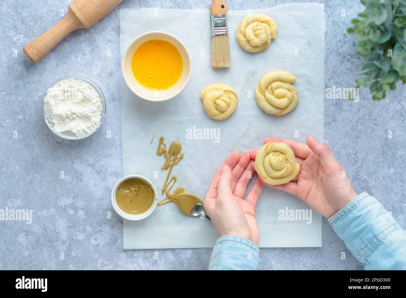 Female's hand holding a raw swirl bun before cooking. Swedish cookies