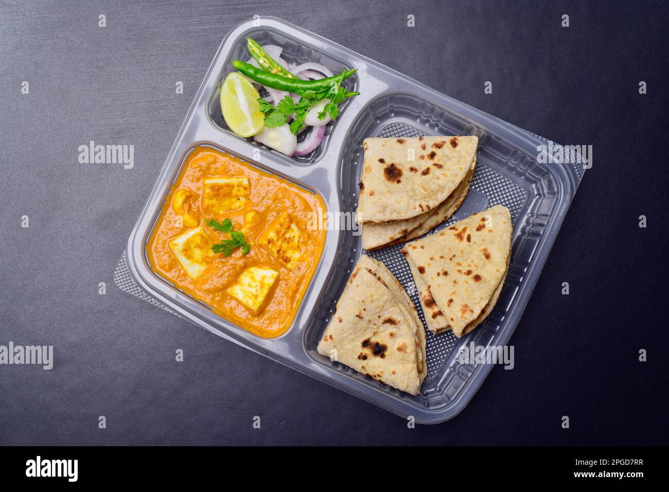 Shahi paneer and tawa roti served with onion chilli in disposable plate Stock Photo