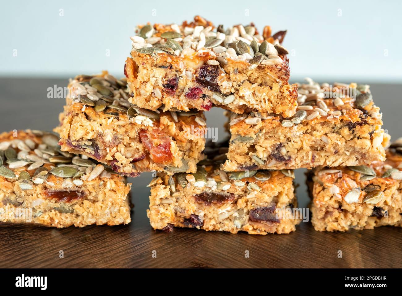 A stack of home made fruit flapjack. The flapjack has been baked with assorted fruit and nuts including dates, sultanas and walnuts Stock Photo