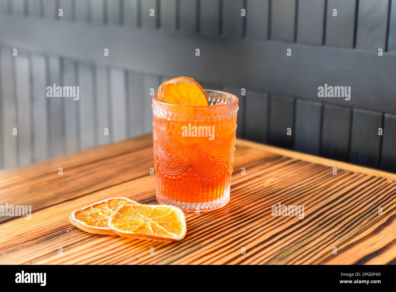 Alcohol cocktail Aperol Spritz with slise of orange on wooden table against dark wall with copy space Stock Photo