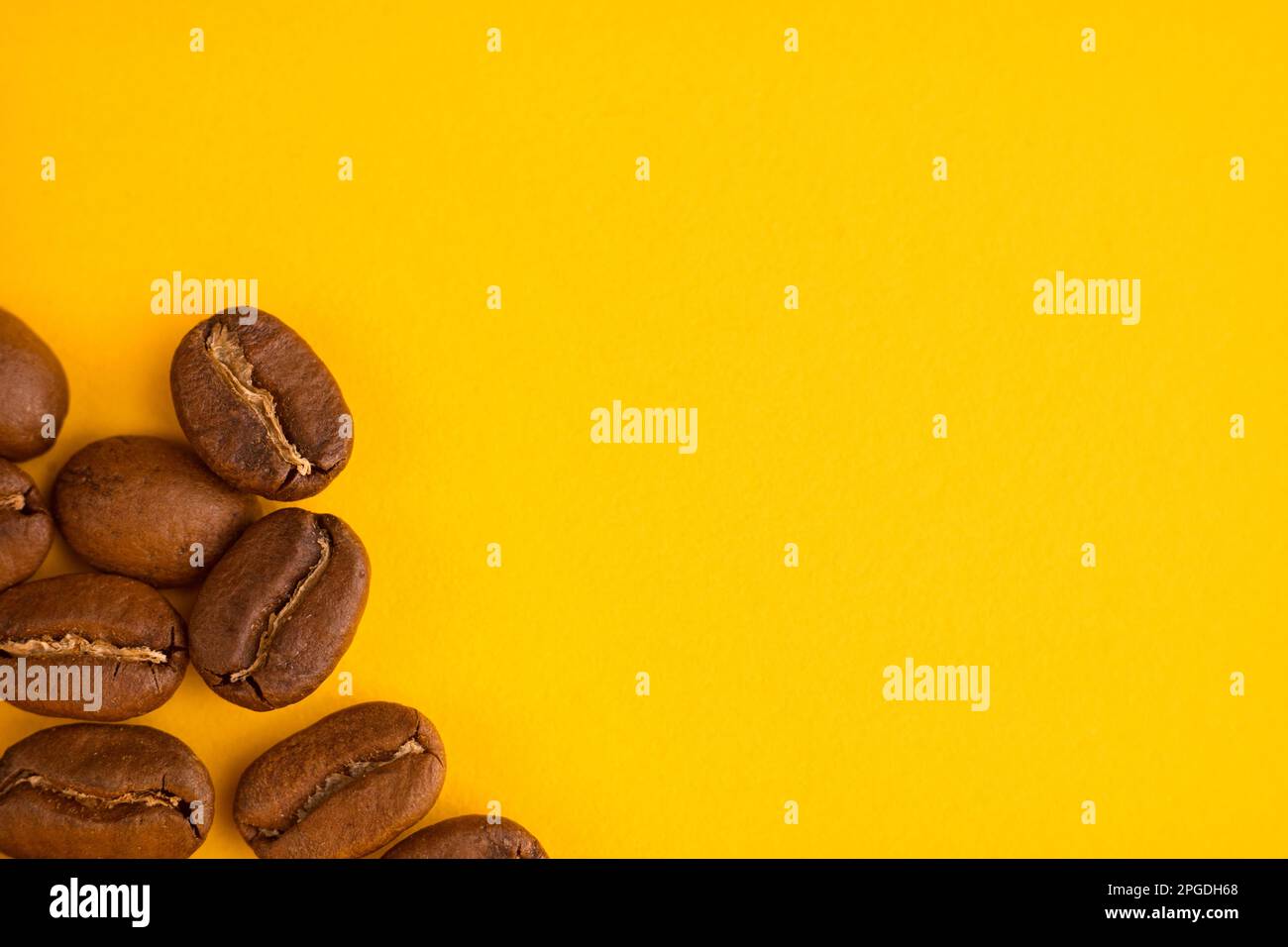 Macro photo of coffee beans on yellow background. Copy space Stock Photo