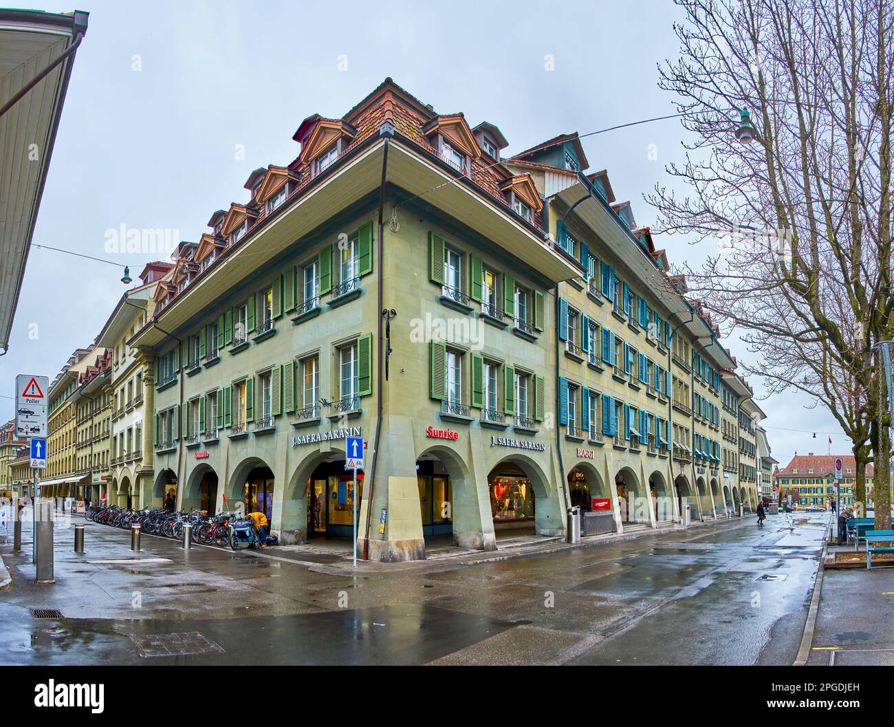 BERN, SWITZERLAND - MARCH 31, 2022: The corner house with typical Bernese walking arcades on Waisenhausplatz and Neuengasse, on March 31 in Bern, Swit Stock Photo