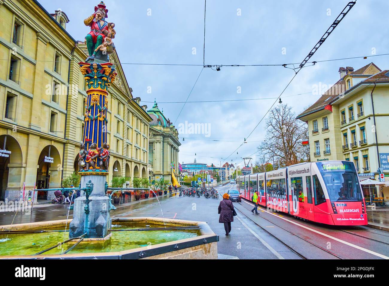 BERN, SWITZERLAND - MARCH 31, 2022: Kornhausplatz sqaure with public transport and medieval Kindlifresserbrunnen fountain, on March 31 in Bern, Switze Stock Photo