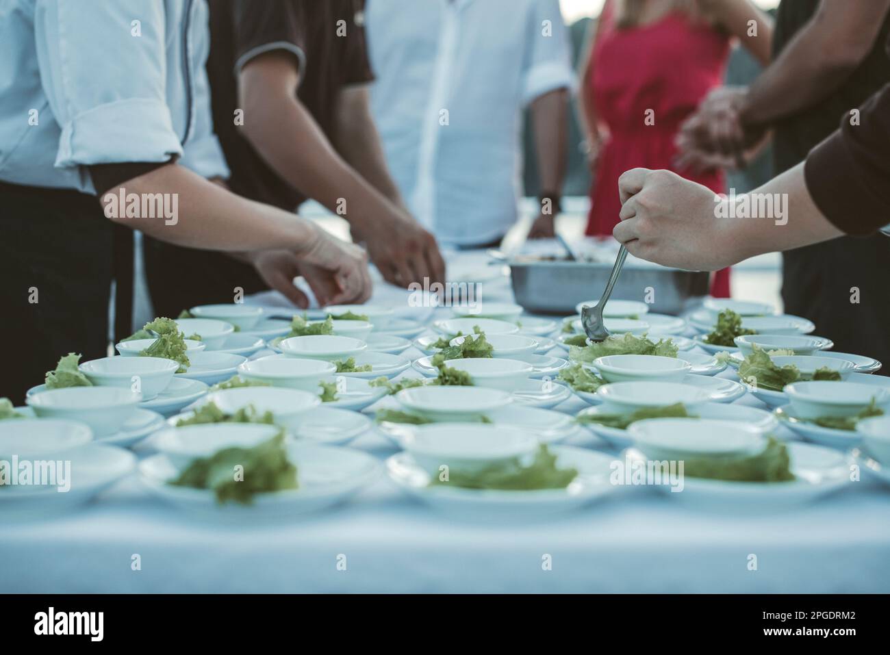 Close-up of caterers preparing plates of food for an event Stock Photo