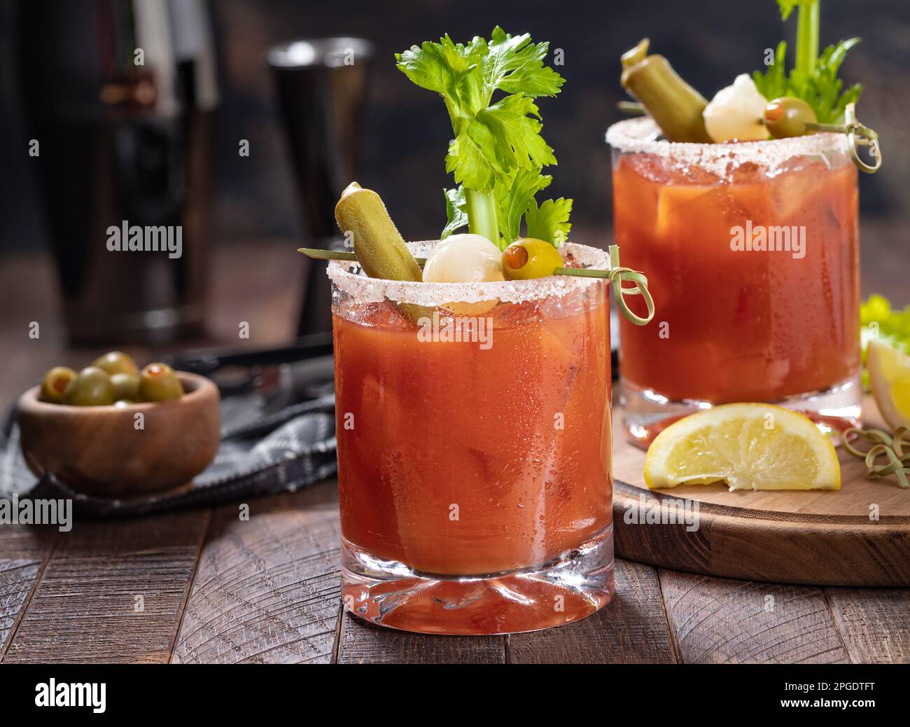 https://c8.alamy.com/comp/2PGDTFT/bloody-mary-cocktail-garnished-with-celery-okra-onion-olive-and-salt-rim-on-a-rustc-wooden-table-2PGDTFT.jpg