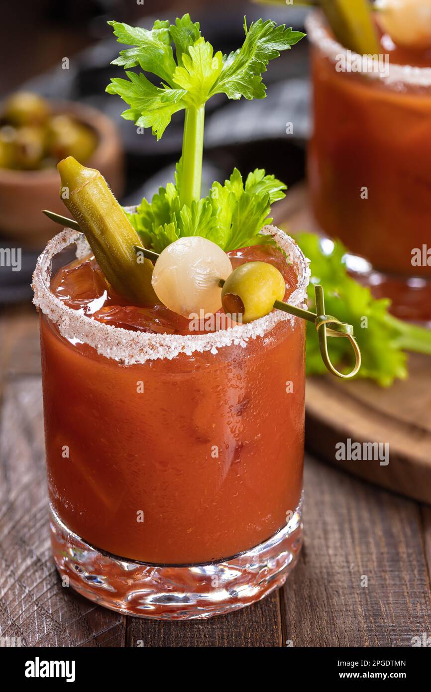 Bloody mary cocktail garnished with celery, okra, onion, olive and salt