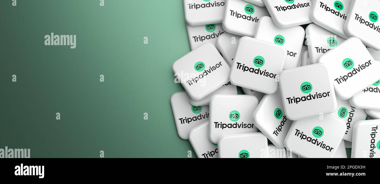 Logos of the online travel agency and review site Tripadvisor on a heap on a table. Web banner format, copy space. Stock Photo
