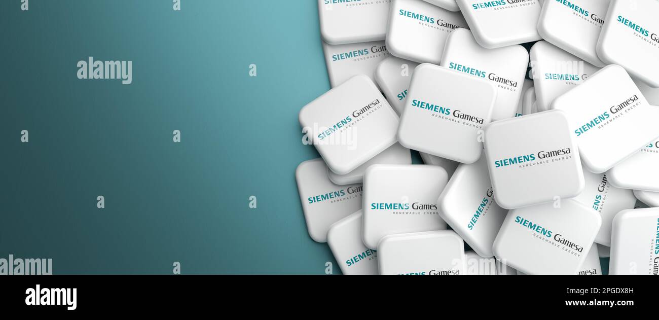 Logos of the manufacturer of wind turbines Siemens Gamesa on a heap on a table. Web banner format, copy space. Stock Photo