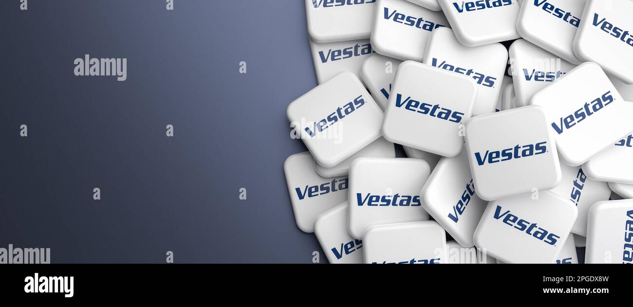 Logos of the manufacturer of wind turbines Vestas on a heap on a table. Web banner format, copy space. Stock Photo