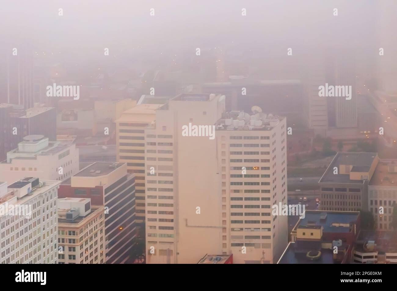 High rises in downtown Atlanta, Georgia, USA, covered in early morning fog on a spring morning, as seen from the Westin Peachtree Plaza Hotel. Stock Photo