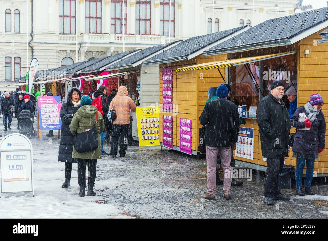 People at Keskustori square by the partie´s huts on first absentee voting day of the parliamentary election in rainy weather in Tampere Finland Stock Photo